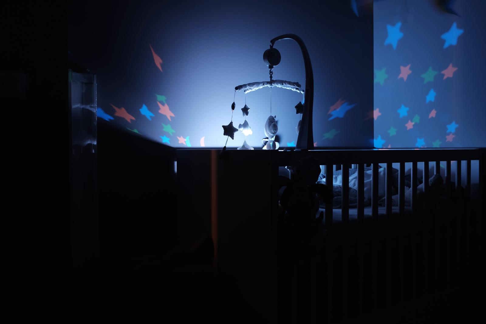 Child in his crib at night with baby monitor helping him stay safe