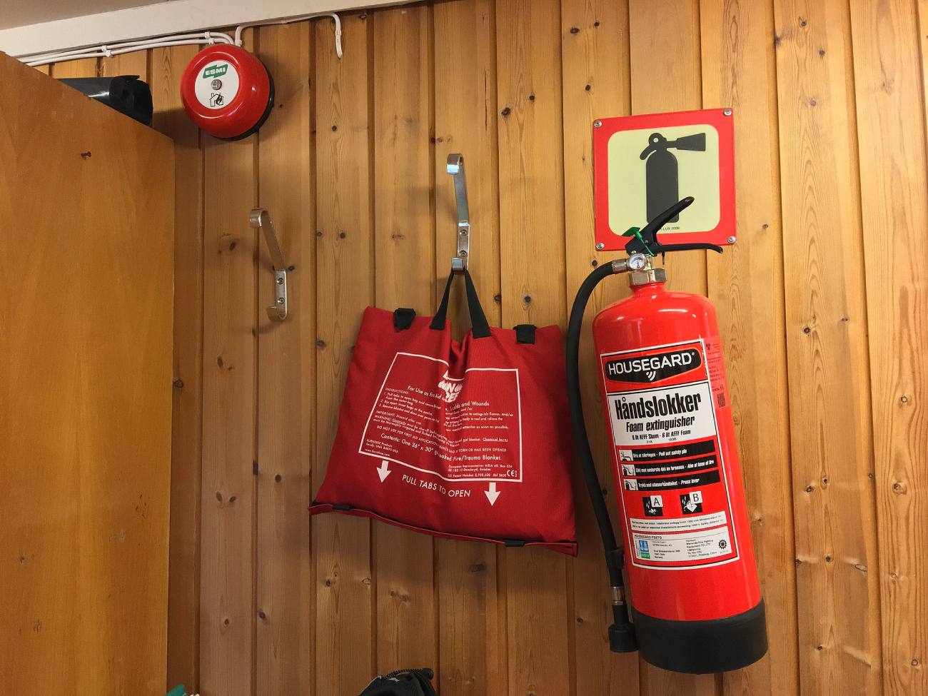 fire blanket hanging on a wall next to a fire extinguisher