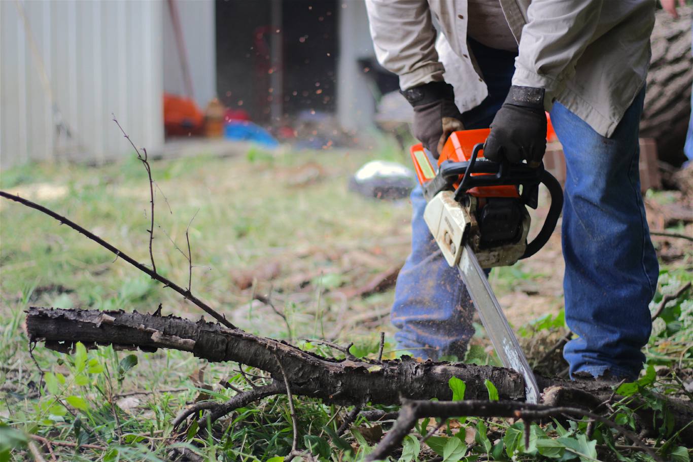 man doing yard work with a chainsaw
