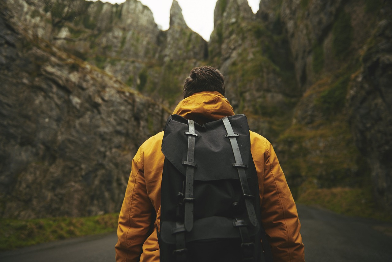man wearing waterproof backpack outside in wilderness.