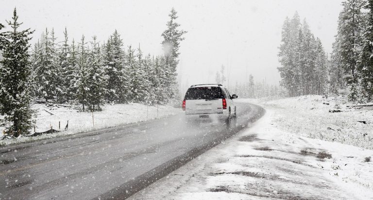 driving down an icy snowy road with Emergency Items To Keep In Your Vehicle